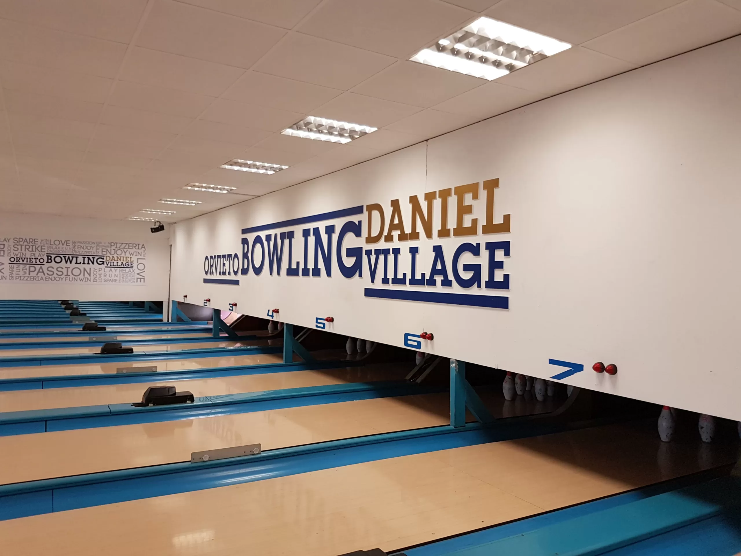 logo a parete lettere in pvc con applicazione in vinile blu e oro, installazione a parete