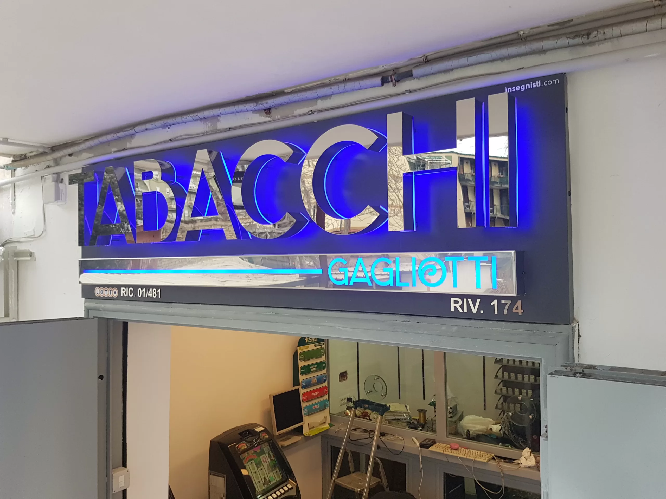 insegna tabacchi a lettere scatolate in acciaio con illuminazione a luce riflessa di colore blu.